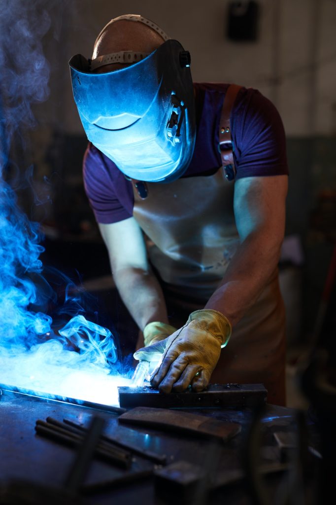 Workman welding metal